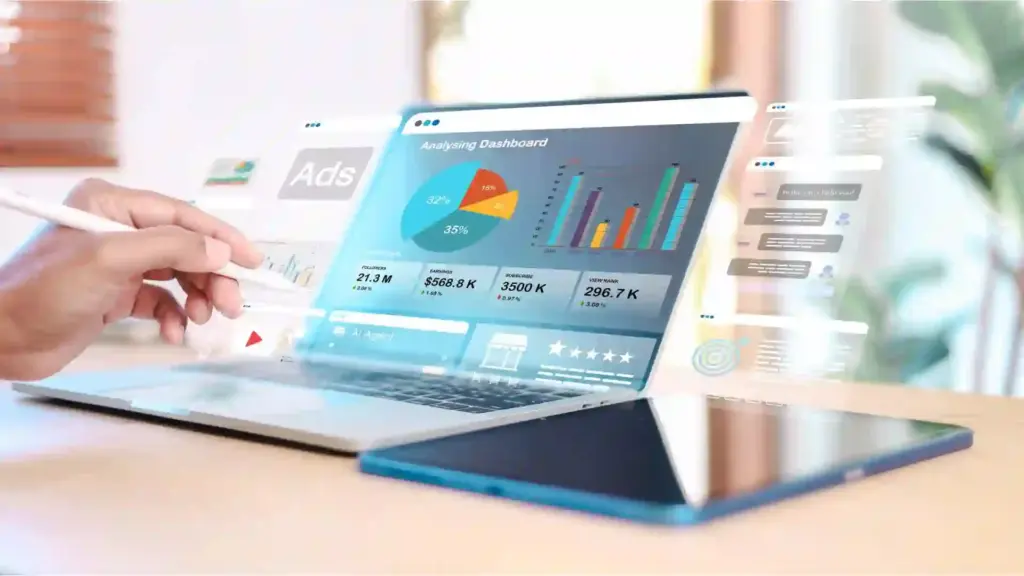Person using a stylus on a laptop that displays a colorful analytics dashboard with pie and bar charts the screen shows data graphs.