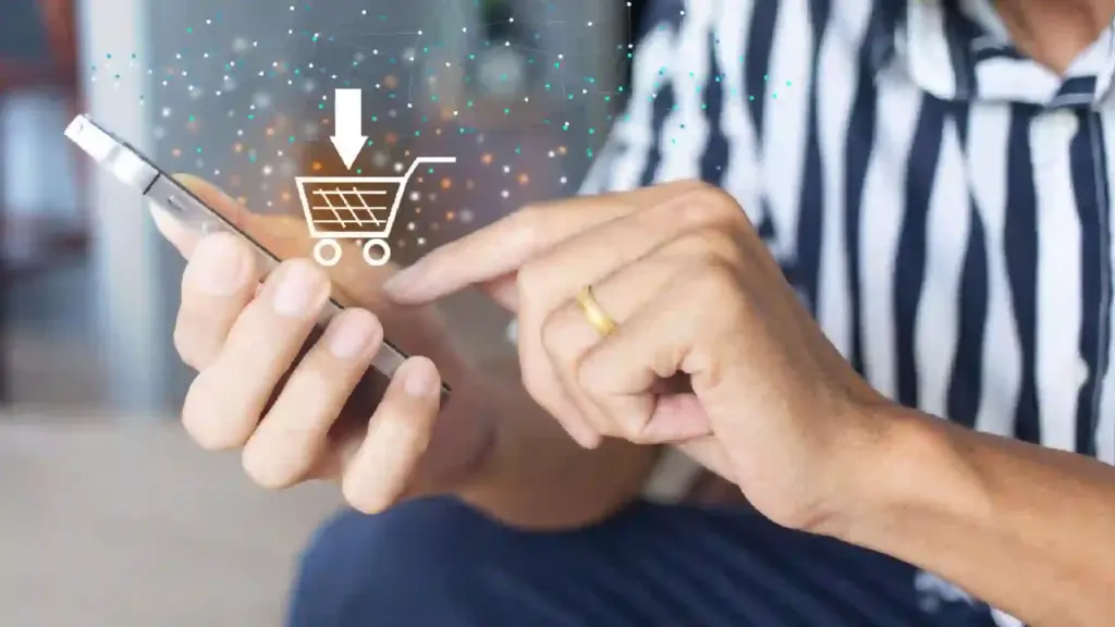 Person using a smartphone with a digital shopping cart icon and downward arrow, representing mobile checkout or online shopping