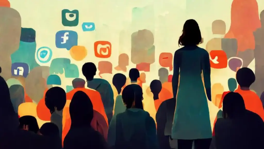 Back view of a speaker standing among a colorful crowd at an event, with social media icons on the wall behind them.